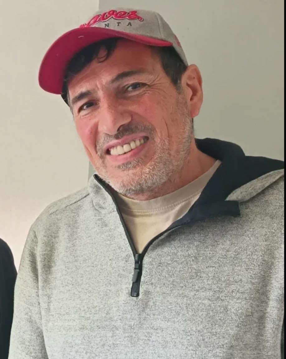 Sergio, casquette rouge, souriant.